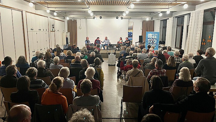 Viele Menschen sitzen im Saal.