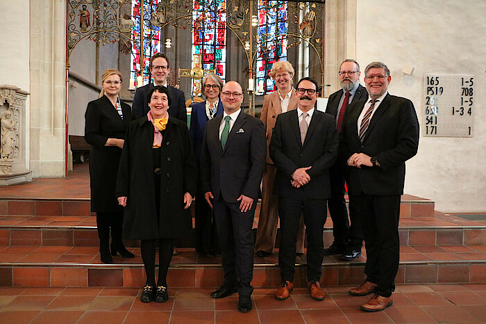 In der Nürtinger Stadtkirche St. Laurentius stehen die Beteiligten des Gottesdienstes auf einer Treppe und schauen lächelnd in die Kamera.